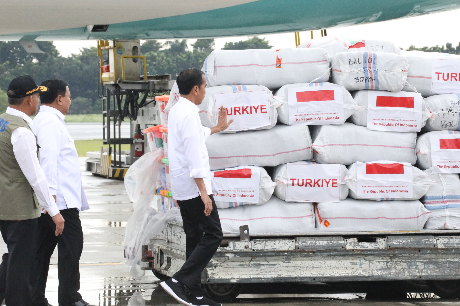 Presiden RI Joko Widodo (kemeja putih) meninjau bantuan logistik yang akan dikirimkan menuju Turkiye di Lanud Halim Perdanakusumah, Jakarta pada Selasa (21/2).